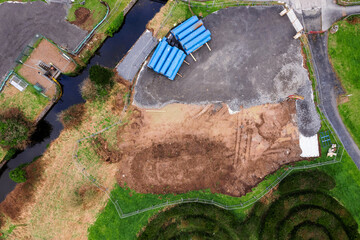 Aerial top down view on pile of big blue plastic pipes in a storage area of a construction site by...