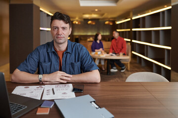 Portrait of entrepreneur working with reports and other business documents