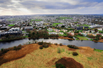 View on Corrib river and village and university buildings. Galway city, Ireland. Blue cloudy sky. Aerial view. High density area. Students accommodation.