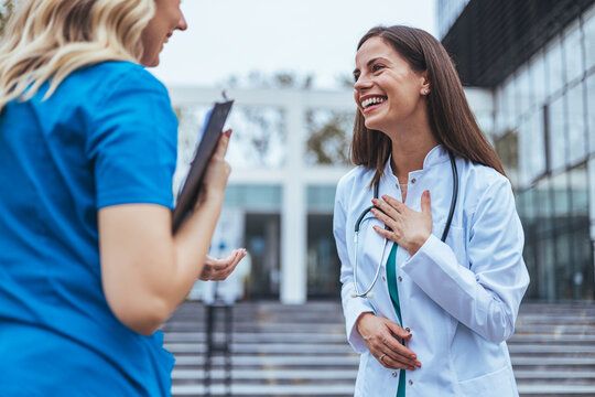 Shot of two medical practitioners using a clipboard together in a hospital. Experienced doctor sharing point of view with colleague. Female nurse and  female doctor discuss patient care