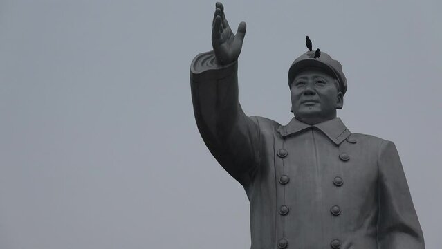 Two birds sit on the head of the former Chairman of the Communist Party in China Mao Zedong
