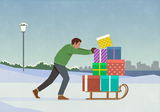 Man pushing sled stacked with Christmas gifts in snowy winter city park

