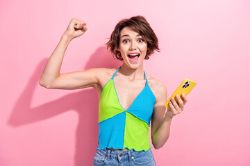 Photo of adorable lucky girl dressed blue green singlet winning game apple samsung iphone modern gadget isolated pink color background