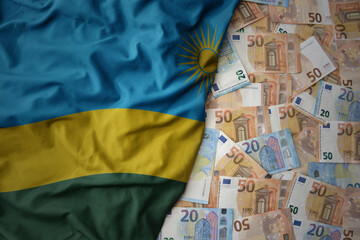colorful waving national flag of rwanda on a euro money background. finance concept