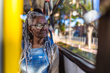 Senior woman with afro hairstyle looking out the bus window.