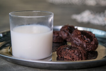 Stack of round chocolate chip cookies and glass of milk on wooden rustic background