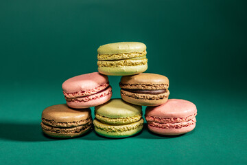 colorful macaroons on a table and on a green background