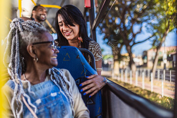 Mulher senior negra conversando com a garota do assento atras do seu no onibus. - obrazy, fototapety, plakaty