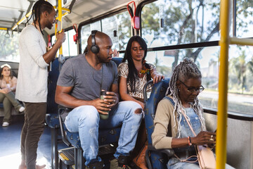 Passageiros multirraciais dentro do onibus em trajeto urbano. - obrazy, fototapety, plakaty