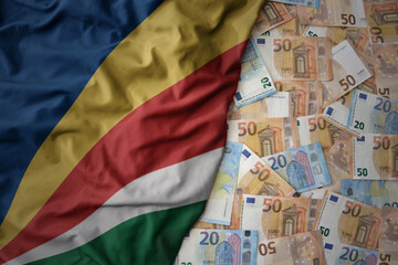 colorful waving national flag of seychelles on a euro money background. finance concept
