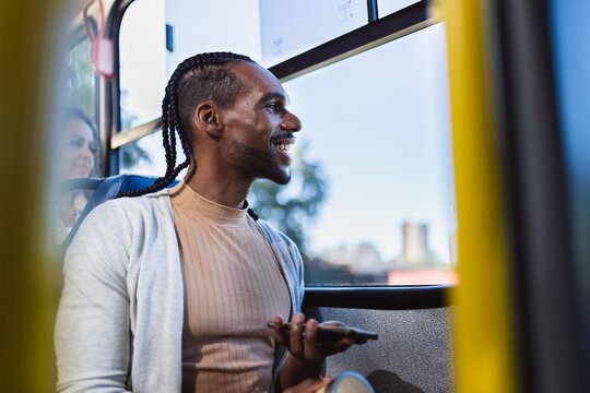 Young black man using smartphone during a bus ride.