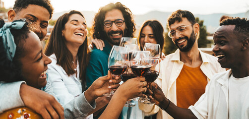 Young people toasting red wine glasses at farm house vineyard countryside - Happy friends enjoying happy hour at winery bar restaurant - Guys and girls having rooftop house party together - obrazy, fototapety, plakaty