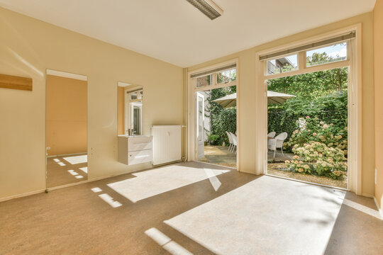 Empty living room with large windows overlooking lush backyard