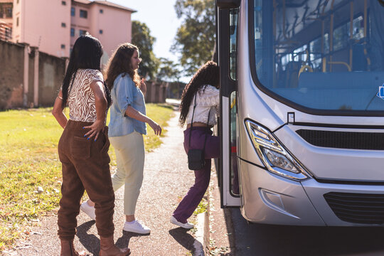 Grupo multiracial de mulheres entrando no onibus.