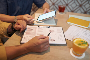 Closeup image of entrepreneurs discussing charts with project performance data