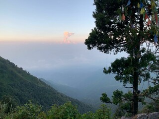 mountains with a tree and sky in the background at sunset