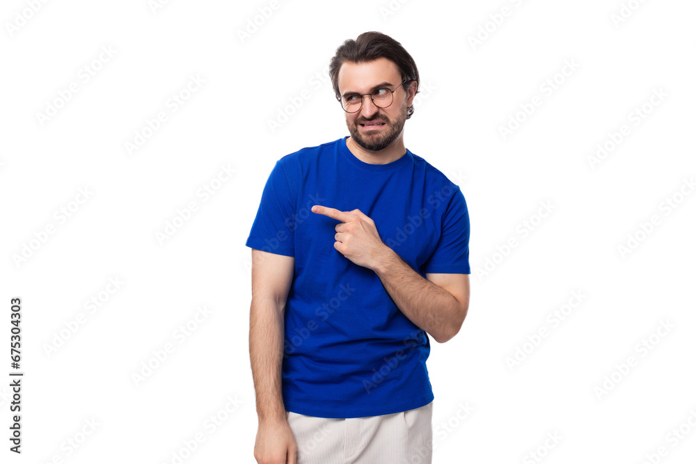 Wall mural portrait of a young caucasian brunette man with a stylish hairstyle and beard in a blue t-shirt with