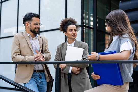 Three business people waiting in front of office building taking a break, before staff meeting. Lawyers and law students on practice outside the court. Professional occupation concept