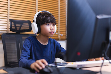 Teenage boy doing homework on computer at home. - obrazy, fototapety, plakaty