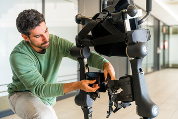 Mechanical exoskeleton engineer checking robot before delivery to customer. Physiotherapy in a...