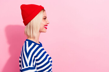 Obraz na płótnie Canvas Profile side view photo of smiling happiness young girl wear red beanie headwear looking interested isolated on pink color background