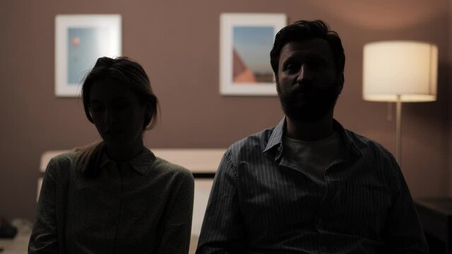 Hidden identity, hidden face, unknown person, silhouette interview. Dark female and male silhouette of woman and man talking to someone and looking at camera or at his interlocutor