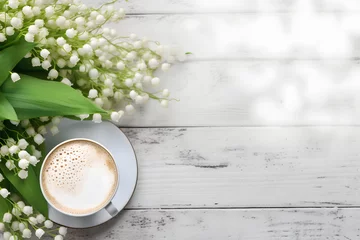 Fotobehang  cup of cappuccino with spring lily of the valley flowers over white wooden table. © nukkix wala