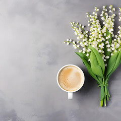 Coffee mug with bouquet of flowers lily of the valley on gray stone table top view in flat lay and minimalistic style. Beautiful morning breakfast.