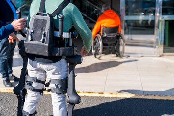 Mechanical exoskeleton, disabled person entering the consultation room walking with the help of the robotic skeleton, physiotherapy in a modern hospital, futuristic physiotherapy