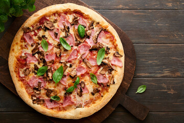 Pizza. Traditional Bacon pizza with ham, mushrooms, pickled cucumber and cheese and cooking ingredients tomatoes basil on wooden table backgrounds. Italian Traditional food. Top view. Mock up.