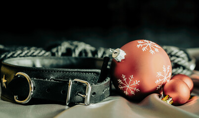 bdsm still life leather collar and christmas balls on silver fabric close up