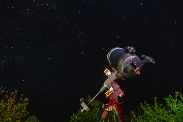 Naklejka premium The astronomical telescope is aimed at the sky and is ready for stargazing. Observation and study of stars and space objects at night