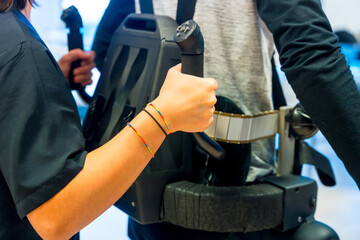 Mechanical exoskeleton. Female physiotherapy medical assistant helping disabled person with robotic skeleton to walk. Futuristic rehabilitation, Physiotherapy in a modern hospital