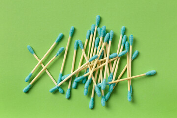 Cotton swabs buds sticks on a green background.