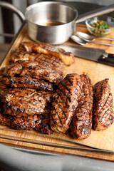 Various types of grilled steaks on a wooden board