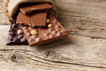Chocolate in a burlap bag on a wooden background.
