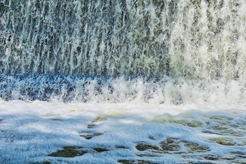Powerful stream of clean water, foam. Waterfall, spa, pool, dam