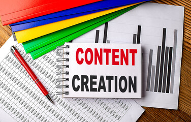 CONTENT CREATION text on a notebook with pen, folder on a chart background