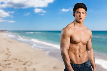 Portrait of handsome young sporty man on the beach
