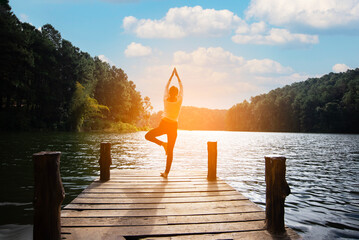 Woman do yoga outdoor. Woman exercising yoga energy at the nature background. Healthy Concept
