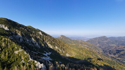 Obraz premium Idyllic scene of mountainous landscapes with evergreen pine trees, against a clear blue sky