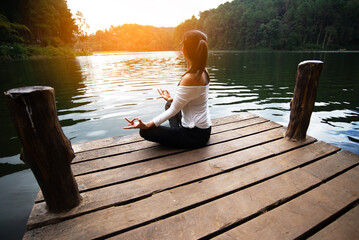 Woman do yoga outdoor. Woman exercising yoga energy at the nature background. Healthy Concept