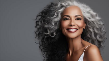 Portrait of smiling mature beautiful black woman over gray background. Beauty, cosmetics skincare...
