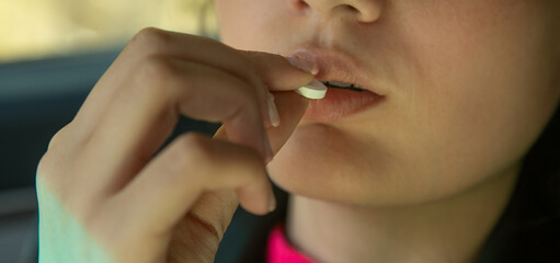 Young caucasian woman taking pill.