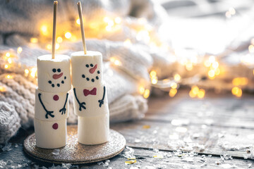 Cozy Christmas background with marshmallow snowmen and festive decor.
