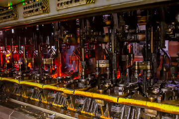 Glass factory, production of glass containers. Molten glass is blown into molds. Robotics in...