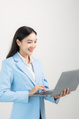 Picture of a young Asian woman Smiling company employee holding a laptop computer standing on a white background.