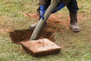 Waste management worker pumping out a residential septic tank.