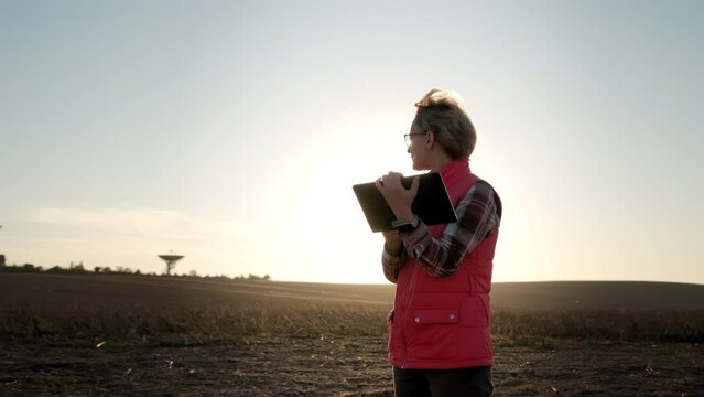 Woman operator equipment tablet pc controls solar radio telescope antennas. Wide view