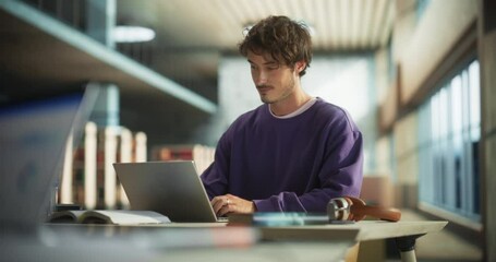 Portrait of a Stylish Male Student Working on His University Exercise on a Laptop Computer. Young Handsome Man Studying an Online College Course in an Empty Quiet Public Library - Powered by Adobe
